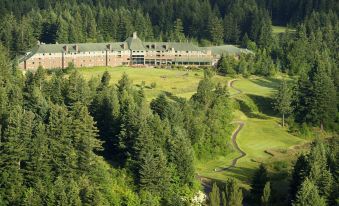 aerial view of a large building surrounded by trees , with a golf course in the foreground at Skamania Lodge