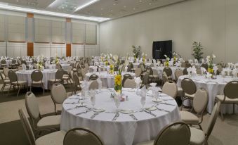 a large dining room filled with round tables and chairs , all set for a formal event at Hilton Shreveport