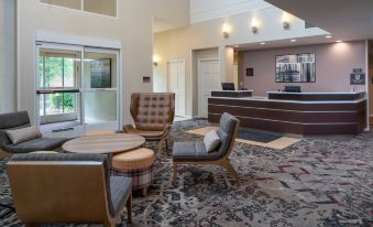 a hotel lobby with a large reception desk , comfortable seating , and a carpet on the floor at Sonesta ES Suites Nashville Brentwood