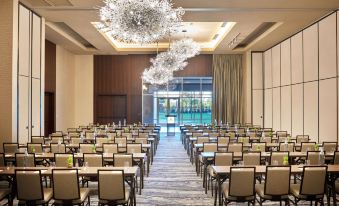 a large conference room with rows of chairs arranged in a semicircle , ready for a meeting or event at The Stella Hotel, Autograph Collection