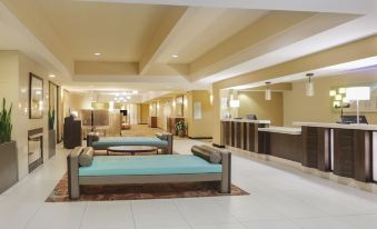 a hotel lobby with two couches , a coffee maker , and a reception desk , all decorated in neutral colors at Holiday Inn Dublin - Pleasanton, an IHG Hotel