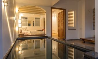 a modern living room with large windows , wooden doors , and a reflecting pool in the center at Over the Hill