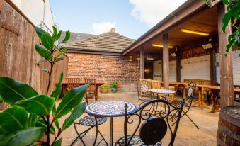 an outdoor patio area with a brick building in the background and a table and chairs in the foreground at The Howard Arms