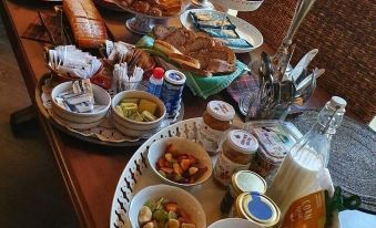 a large dining table filled with a variety of food items , including sandwiches , fruits , and beverages at CasAda