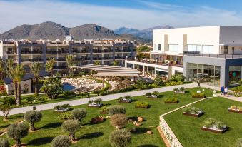 a large hotel surrounded by lush greenery , with a swimming pool in the center of the property at Zafiro Palace Alcudia