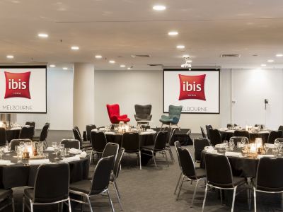 a large conference room with multiple tables and chairs arranged for a meeting or event at Ibis Melbourne Hotel and Apartments