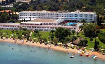 aerial view of a large resort on the beach , with several people enjoying their time in the water and on the sand at Ikos Dassia