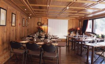 a conference room set up for a meeting , with multiple chairs arranged in rows and a projector on the wall at Hotel Mont Blanc