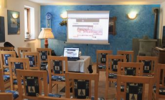 a room with a projector screen displaying an image and several chairs arranged around it at Hotel Lo Scoiattolo