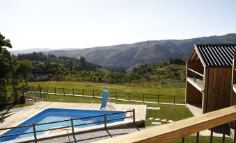 a large swimming pool is surrounded by a wooden deck and a fence , with mountains in the background at Casa de Lobos