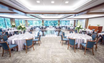a large , well - lit room with multiple dining tables and chairs set up for a formal event or gathering at Inn at Villanova University