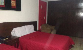 a hotel room with two beds , one on the left and one on the right side of the room at Hotel Mexico