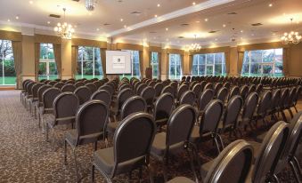 a large conference room with rows of chairs arranged in a semicircle , ready for a meeting or presentation at Macdonald Craxton Wood Hotel