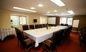 a large conference room with a long table and several chairs arranged for a meeting at Fairways Lodge & Leisure Club