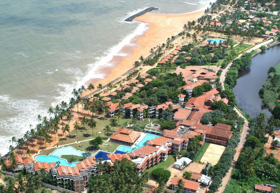 an aerial view of a resort with multiple buildings , swimming pools , and a beach in the background at Club Hotel Dolphin