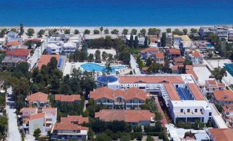 an aerial view of a beach resort with multiple buildings and a pool , surrounded by trees at Alkyon Resort Hotel & Spa