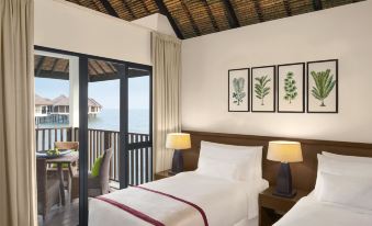a bedroom with a bed , lamps , and a sliding glass door leading to an outdoor balcony at Avani Sepang Goldcoast Resort