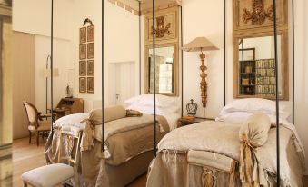 a bedroom with two beds , one on each side of the room , and a mirror hanging above the beds at Torre de Palma Wine Hotel, Montforte, a Member of Design Hotels