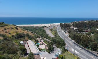 a bird 's eye view of a road near the ocean with houses and trees in the foreground at Malibu Country Inn