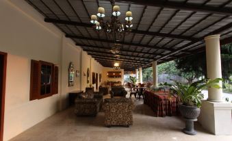 a spacious living room with a couch , chairs , and dining table under a covered area at Griya Gendhis Saraswati
