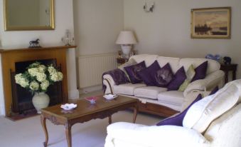 a spacious living room with a white couch , wooden coffee table , and a large mirror on the wall at Buckley Farmhouse