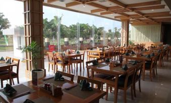 a large , open dining room with multiple tables and chairs arranged for a group of people at Sakura Park Hotel & Residence