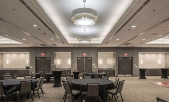 a large , empty banquet hall with multiple round tables and chairs set up for an event at SpringHill Suites Dallas Rockwall
