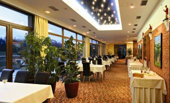 a large , well - lit dining room with multiple tables and chairs arranged for a group of people at Hotel International