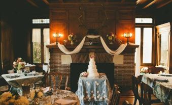 a wedding reception with a cake on a table in front of a fireplace and a large mirror at Black Swan Inn