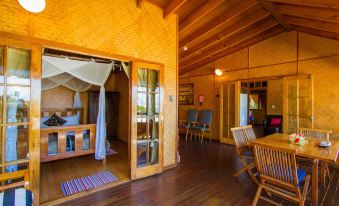 a spacious , wooden interior with multiple dining tables and chairs , as well as a kitchen area at 1770 Beach Shacks