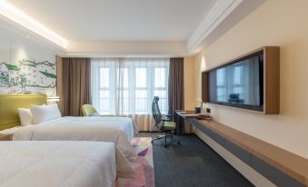 The bedroom features double beds, large windows, and a wall-mounted flat-screen TV at Hampton by Hilton Ji'an