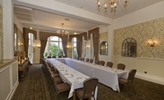 a long dining table set up for a formal event , with multiple chairs arranged around it at St Andrews Town Hotel