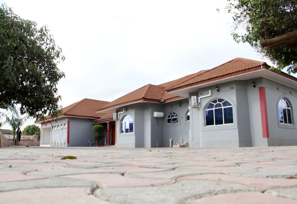 An empty house is situated between two white houses in the front and one on the other side at Twalumba Lodges