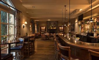 a dimly lit restaurant with wooden tables and chairs , a bar area , and a fireplace at Lafayette Park Hotel & Spa