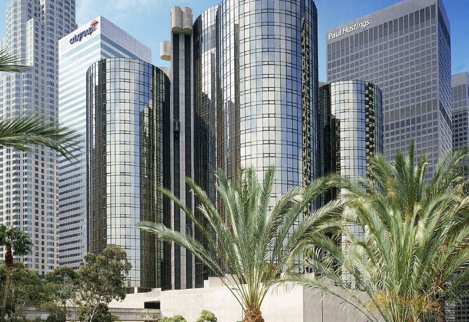 a city skyline with tall buildings , palm trees , and a bridge , set against a clear blue sky at The Westin Bonaventure Hotel & Suites, Los Angeles