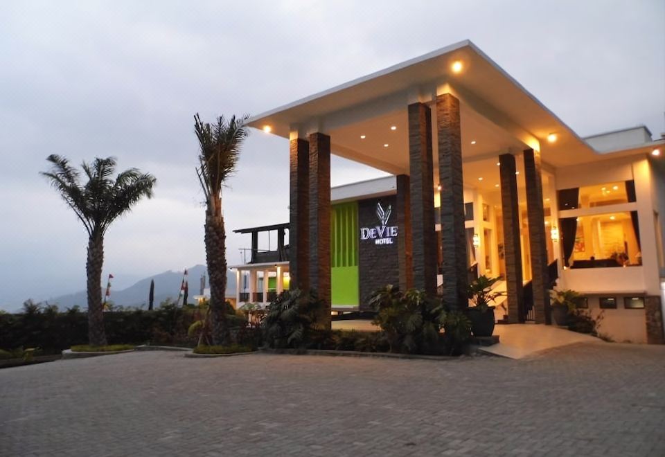 "a large building with a sign that says "" da silva "" and palm trees in front of it" at De View Hotel