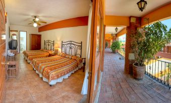a bedroom with a large bed and a sliding door leading to an outdoor patio area at Hotel Hacienda