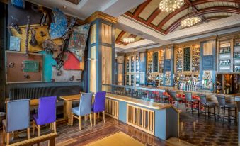 a modern bar with wooden furniture , a bar area , and a large mural on the wall at Talbot Hotel Wexford