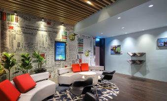 a modern hotel lobby with various seating options , including couches , chairs , and a coffee table at Ibis Melbourne Hotel and Apartments