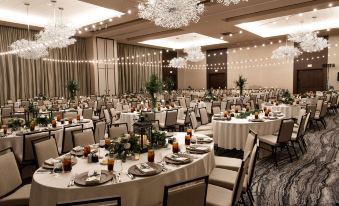 a large banquet hall with round tables and chairs set up for a formal event at The Stella Hotel, Autograph Collection