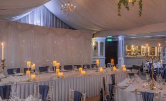 a long dining table set up for a wedding reception , with multiple candles placed on the table at Bunratty Castle Hotel