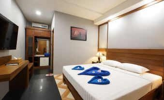 a clean and well - organized hotel room with a bed , a tv , and a bathroom at Sunny Villa