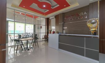 a modern office space with a reception area , dining table , chairs , and a red ceiling at RedDoorz Plus Near Uin Raden Fatah Palembang