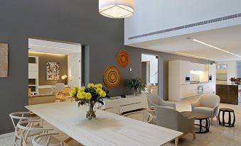 a modern living room with a white dining table and chairs , a couch , and a television at Crystalbrook Byron