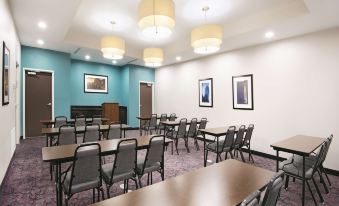 a large conference room with multiple rows of chairs arranged in a semicircle around a long table at La Quinta Inn & Suites by Wyndham Houston Humble Atascocita