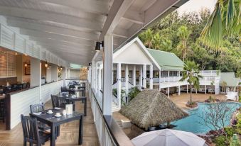 a covered outdoor dining area with several tables and chairs , providing a pleasant atmosphere for guests to enjoy their meals at Malolo Island Resort