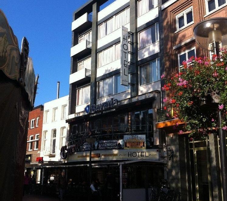 a city street with a building on the left side and another building on the right side at Crown Inn