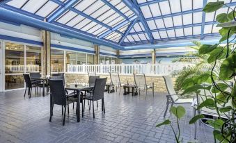 an outdoor dining area with several tables and chairs , providing a pleasant atmosphere for patrons to enjoy their meals at Best Western Weymouth Hotel Rembrandt