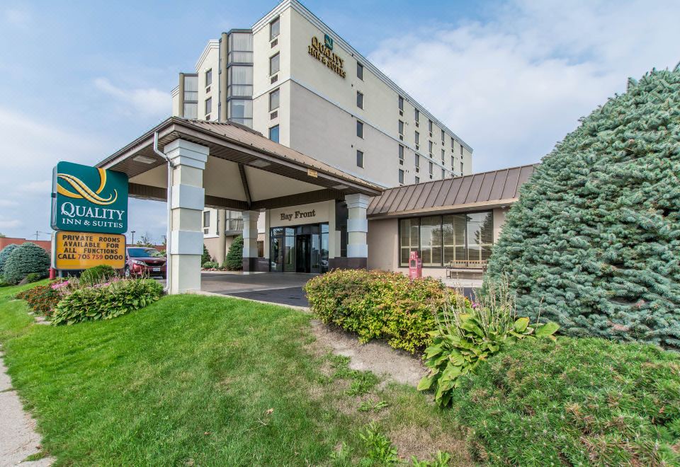 an exterior view of a hotel with a large sign above the entrance , surrounded by greenery at Quality Inn & Suites Bay Front