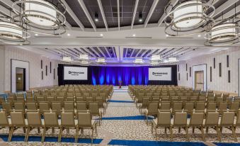 a large conference room with rows of chairs arranged in a semicircle , and a podium at the front of the room at Wyndham Grand Clearwater Beach